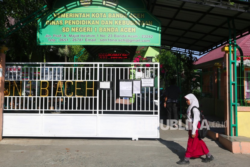 Pelajar keluar dari pekarangan sekolah SD Negeri 1 yang telah diliburkan di Banda Aceh, Aceh, Senin (16/3/2020).(Antara/Irwansyah Putra)