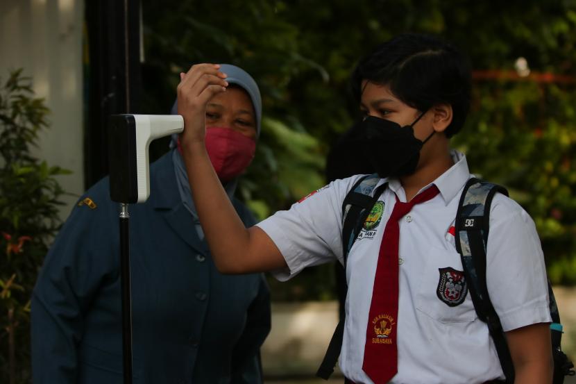 Pelajar mengecek suhu badannya sebelum memasuki ruang kelas di SDN Kaliasin I, Surabaya, Jawa Timur, Senin (6/9/2021). Pemkot Surabaya memulai pembelajaran tatap muka (PTM) tingkat Sekolah Dasar (SD) dan Sekolah Menengah Pertama (SMP) secara terbatas dengan menerapkan protokol kesehatan secara ketat