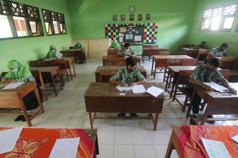 Pelajar mengerjakan soal ujian matematika di SMP Negeri 2 Tarokan, Kediri, Jawa Timur, Rabu (24/3/2021). Meskipun pembelajaran masih secara daring, pemerintah daerah setempat mengizinkan sekolah tingkat SMP hingga SMA menggelar Ujian Satuan Pendidikan (USP) secara tatap muka dengan menerapkan protokal kesehatan COVID-19. 