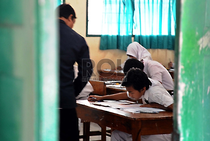 Pelajar mengerjakan soal Ujian Nasional di sekolah MTSN 9, Johar Baru, Jakarta Pusat, Senin (4/5).  (Republika/Tahta Aidilla)