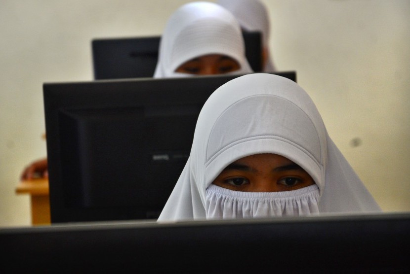 Pelajar mengikuti Ujian Nasional Berbasis Komputer (UNBK) di SMK Fadris, Kampung Cisayong, Kabupaten Tasikmalaya, Jawa Barat, Senin (3/4). 