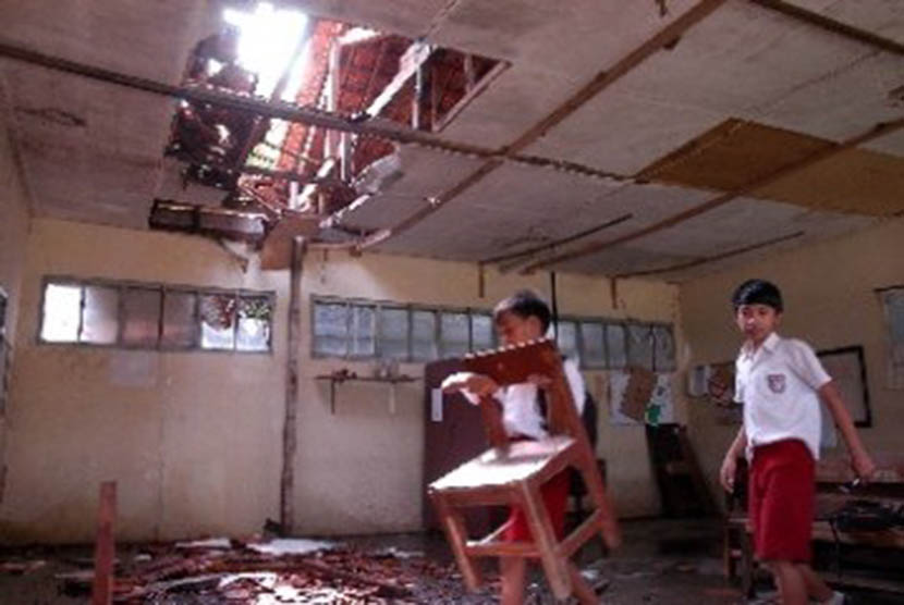 Pelajar menyelamatkan kursi yang masih bisa dipakai dari ruangan kelas yang rusak parah di SD Negeri Batutulis 04, Bogor Selatan, Kota Bogor, Jabar, Selasa (24/5). 