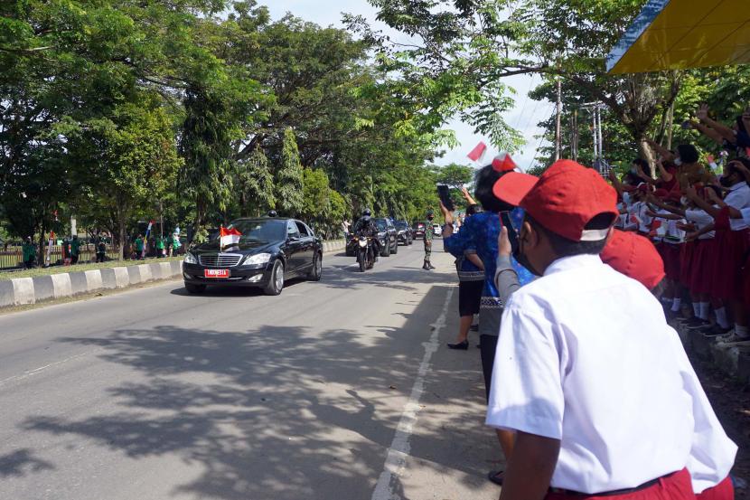 Pelajar SD mengibarkan bendera merah putih menyambut kedatangan Presiden Joko Widodo yang melintas di jalan Kota Sorong, Papua Barat, Senin (4/10/2021). Masyarakat Sorong antusias menyambut kedatangan Jokowi yang berkunjung ke Sorong dalam rangka kunjungan kerja