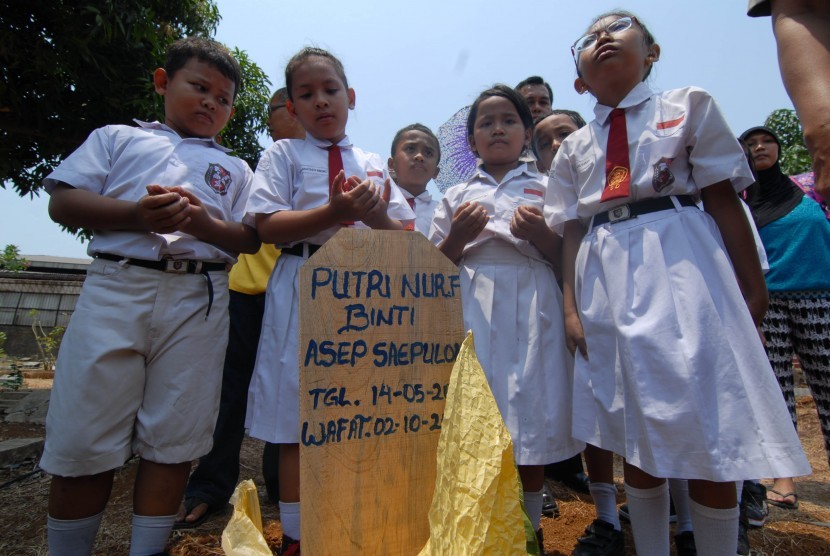 Pelajar SD Negeri 05 Pagi Kalideres berdoa bersama di makam korban pembunuhan, Kalideres, Jakarta Barat, Senin (5/10). 