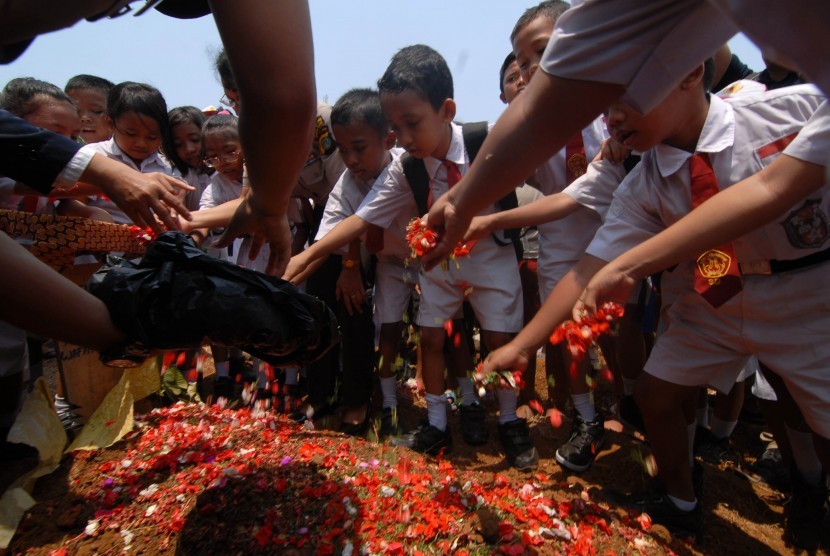 Pelajar SD Negeri 05 Pagi Kalideres menabur bunga di makam Putri Nur Fauziah yang menjadi korban pembunuhan, Kalideres, Jakarta Barat, Senin (5/10). 
