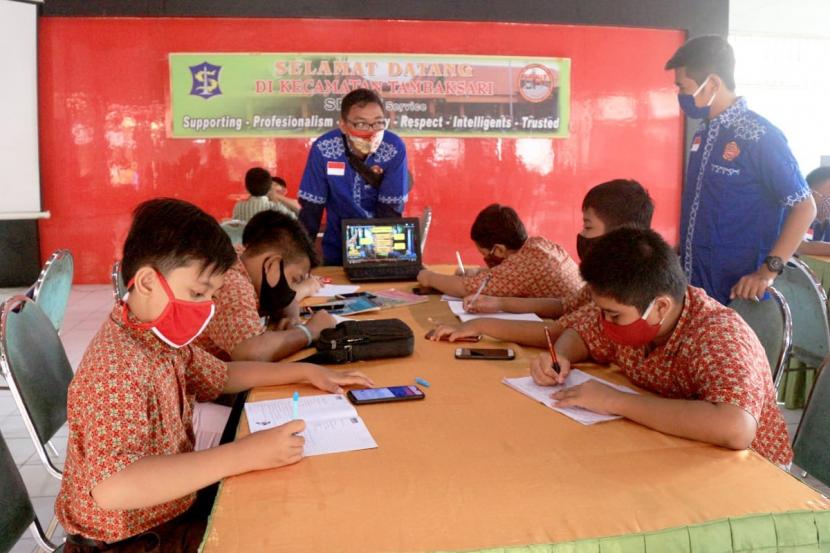 Pelajar Sekolah Dasar (SD) dan Sekolah Menengah Pertama (SMP) memanfaatkan akses wifi gratis di pendopo Kantor Kecamatan Tambaksari Surabaya untuk menjalani belajar daring, Kamis (6/8