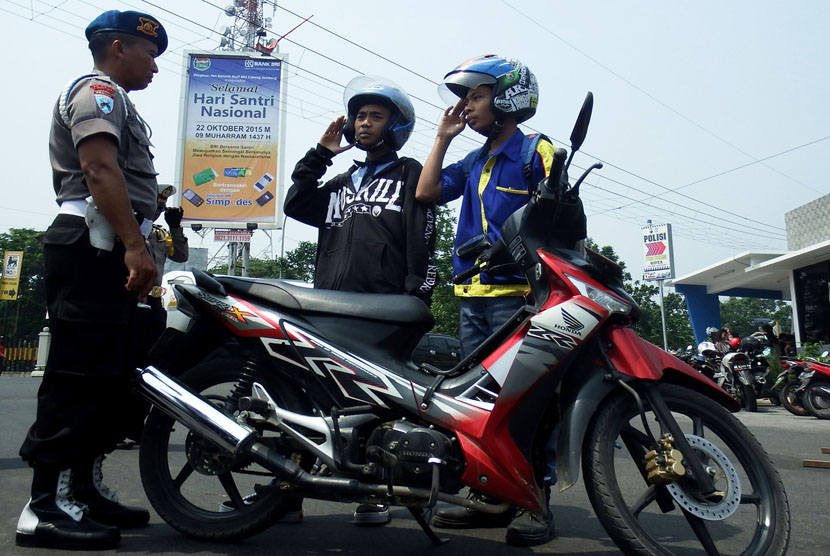 Pelajar yang melanggar lalu lintas diberi sanksi menyanyikan lagu kebangsaan Indonesia Raya dihadapan petugas saat Operasi Zebra di Jombang, Jawa Timur, Kamis (298/10).