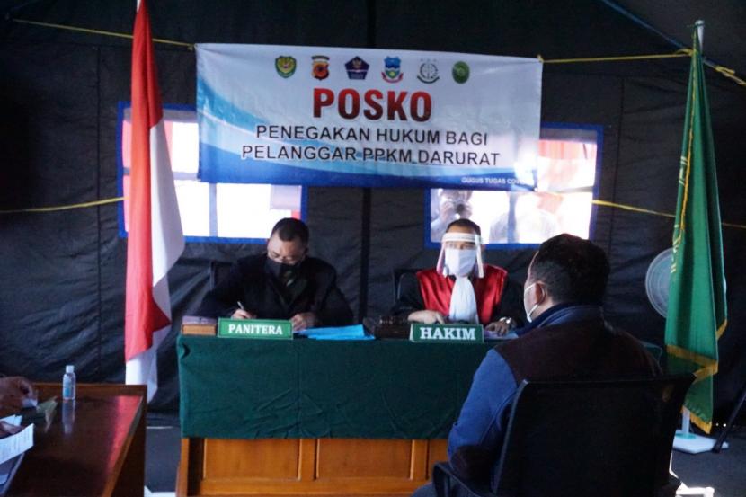 Pelaksanaan sidang pelanggaran PPKM darurat yang dilaksanakan di posko penegakan hukum bagi pelanggar PPKM darurat yang berlokasi di Simpang Lima, Kecamatan Tarogong Kidul, Kabupaten Garut, Selasa (6/7).