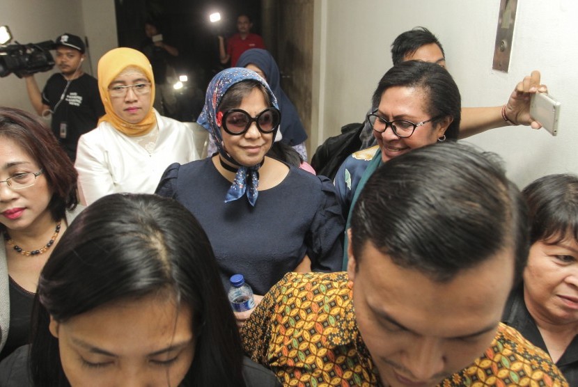 Pelaku penamparan petugas keamanan penerbangan Joice Waraouw (tengah) berjalan saat memenuhi panggilan petugas Kepolisian di Mapolda Metro Jaya, Jakarta, Jumat (7/7). J
