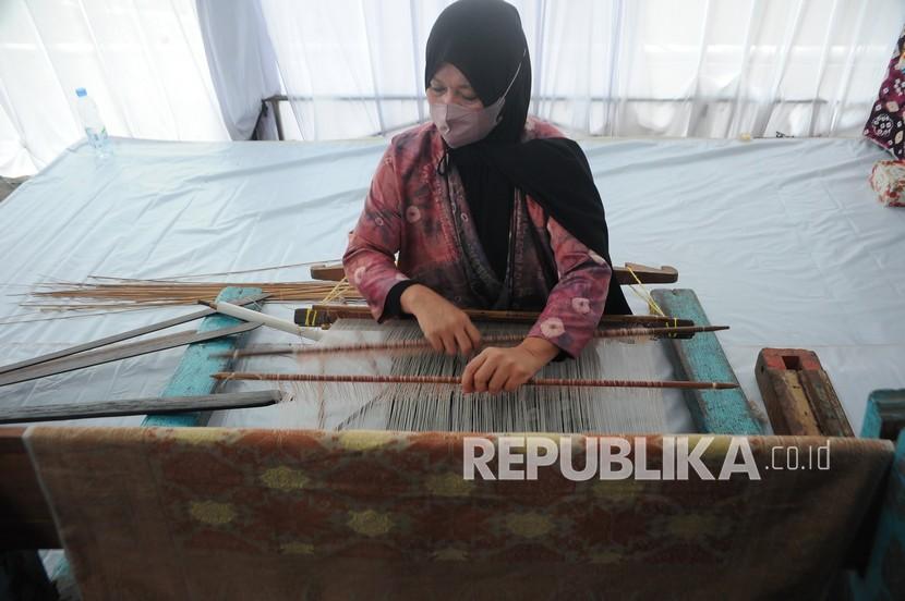 Pelaku usaha menenun kain songket berbahan benang pewarna alami pada peluncuran Pemberdayaan UMKM Kemenkeu Satu di Gedung Keuangan Negara Palembang, Sumsel, Jumat (18/3/2022). Kemenkeu melalui DJKN mendirikan unit UMKM di Provinsi Sumsel untuk mendorong pelaku usaha setempat melakukan ekspor dan meningkatkan kualitas produknya melalui pendampingan. 