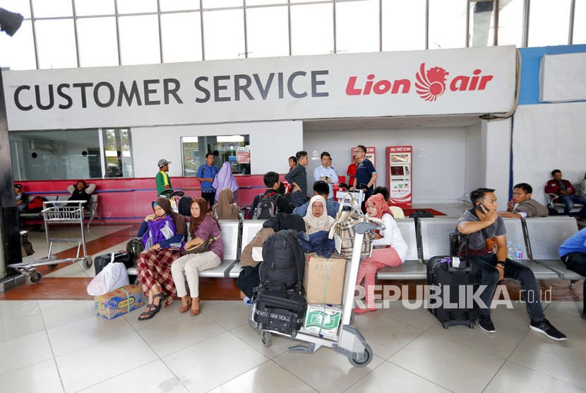 Pelanggan duduk di dekat konter Lion Air di Bandara Internasional Soekarno-Hatta di Tangerang, Senin (29/10/2018) 