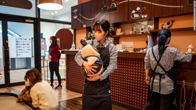 Pelanggan memeluk robot Lovot di sebuah kafe di Jepang pada Desember 2020.