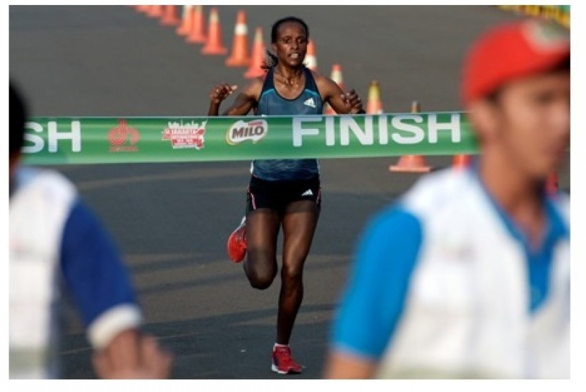 Pelari Ethiopia Atsede Habtamu Besuye memasuki garis finis dalam lomba lari Jakarta International 10K 2015 di Silang Monas, Jakarta Pusat, Ahad (31/5).