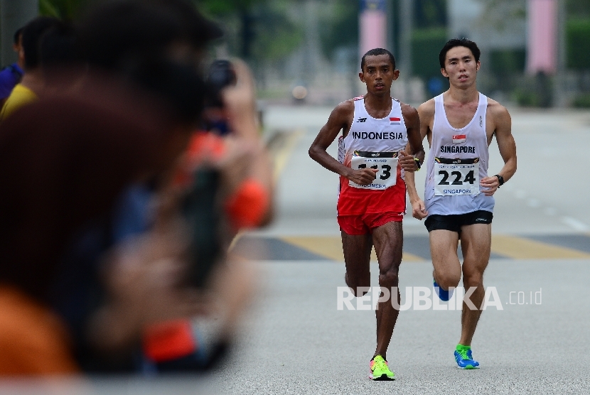 Pelari Indonesia Agus Prayogo bersaing ketat dengan pelari Singapura Soh Rui Yong saat bertanding pada nomor lari marathon SEA Games XXIX Kuala Lumpur di Putrajaya, Malaysia, Sabtu (19/8).