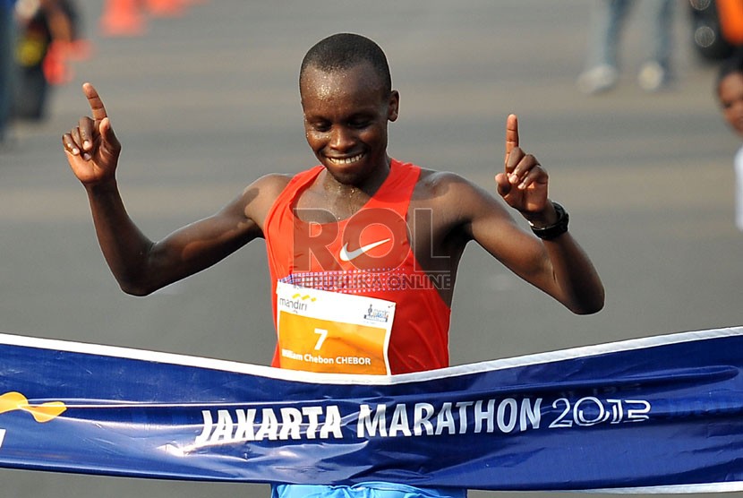  Pelari Kenya, Chebor William Chebon, menyentuh garis finis pertama dalam ajang lomba lari Jakarta Marathon 2013, kategori putra Full Marathon, di kawasan Monas, Jakarta, Ahad (27/10). (Republika/Prayogi)