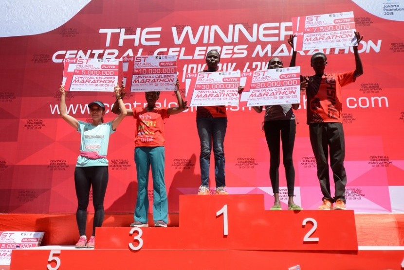 Pelari pemenang kategori putri menaiki podium saat penyerahan hadiah juara Central Celebes Marathon di Palu, Sulawesi Tengah, Ahad (15/4). Lomba lari maraton 42 kilometer yang diikuti 82 peserta dari 18 negara itu dimenangkan oleh Purity Jelimo Serem asal Kenya dengan catatan waktu 03:06:02. 