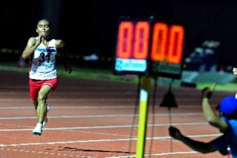Pelari putri Indonesia, Triyaningsih, berlari menuju garis finis pada pertandingan lari nomor 10 ribu meter SEA Games 2011 di Stadion Atletik Jakabaring Sports City, Palembang, Sabtu (13/11).