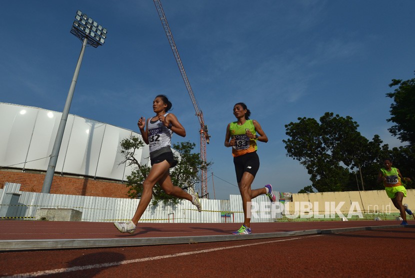 Pelari putri NTT Olivia Sadi (kanan) dan pelari DKI Jakarta Odekta Vina berlari pada nomor 10 ribu meter putri Kejurnas Atletik di Stadion Rawamangun, Jakarta, Kamis (7/12). 