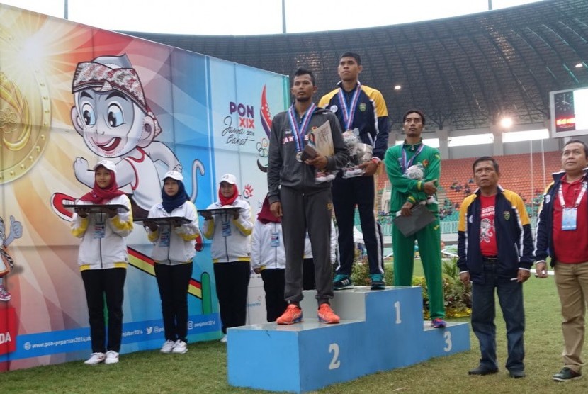 Pelari Sumatera Selatan (Sumsel) sekaligus anggota Paspampres, Rio Maholtra (tengah) meraih medali emas lari gawang 110 meter.