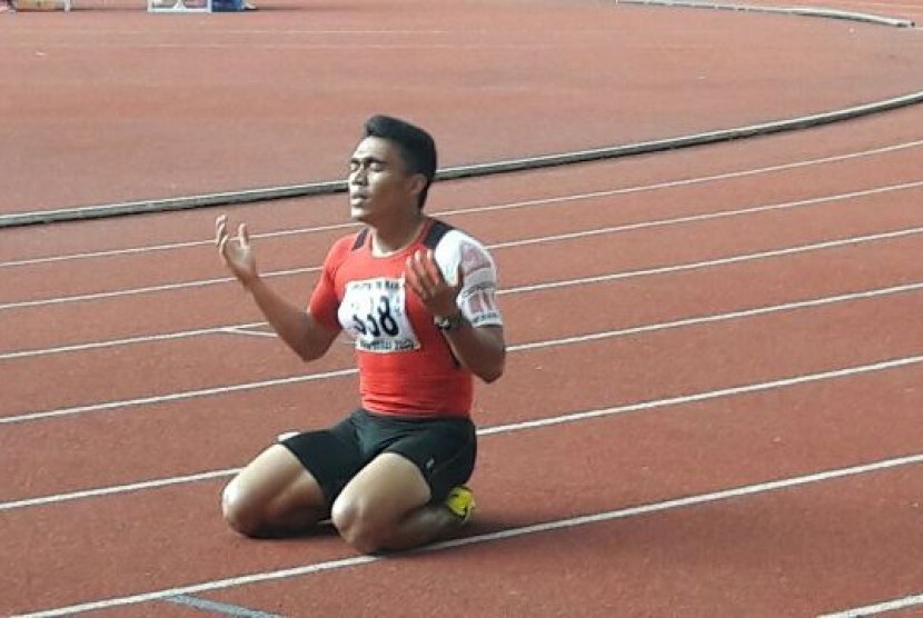 Pelari Sumatra Barat, Yaspi Boby mengucap syukur setelah menjadi yang tercepat di nomor 200 meter PON XIX Jabar, di Stadion Pakansari, Bogor, Jumat (23/9). Yaspi sebelumnya juga telah berhasil meraih emas nomor 100 meter.