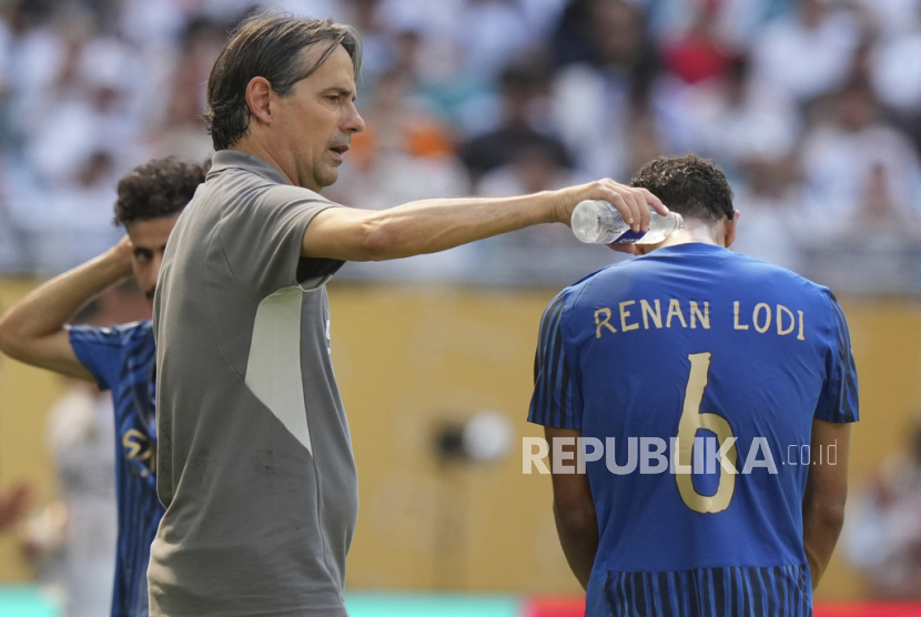Pelatih Al Hilal Simone Inzaghi (kiri) menggunakan air mineral untuk mendinginkan pemainnya Renan Lodi selama pertandingan sepak bola Grup H Piala Dunia Antarklub melawan Real Madrid di Miami, Florida, Kamis, 19 Juni 2025. 
