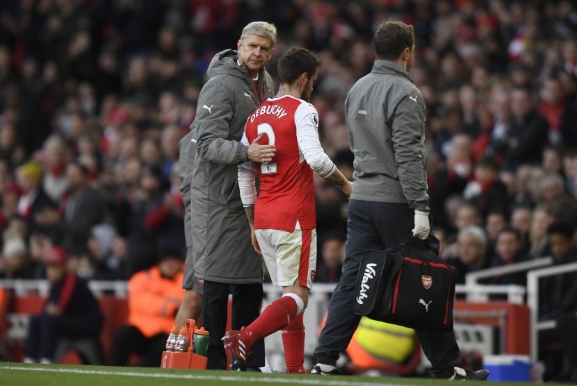 Pelatih Arsenal (kiri) menarik keluar Mathieu Debuchy (tengah) pada laga Liga Primer lawan Bournemouth di stadion Emirates, Ahad (27/11). Selain Debuchy, Olivier Giroud juga mengalami cedera pada laga itu.