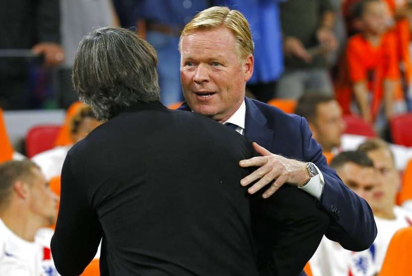 Pelatih Belanda Ronald Koeman (kanan) memeluk pelatih Jerman Joachim Loew.