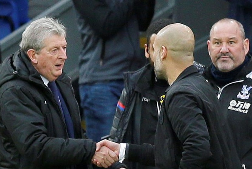 Pelatih Crystal Palace, Roy Hodgson (kiri) bersalaman dengan pelatih Manchester City, Pep Guardiola pada laga Liga Primer di Selhurst Park, London, Ahad (31/12). Laga berakhir imbang 0-0.