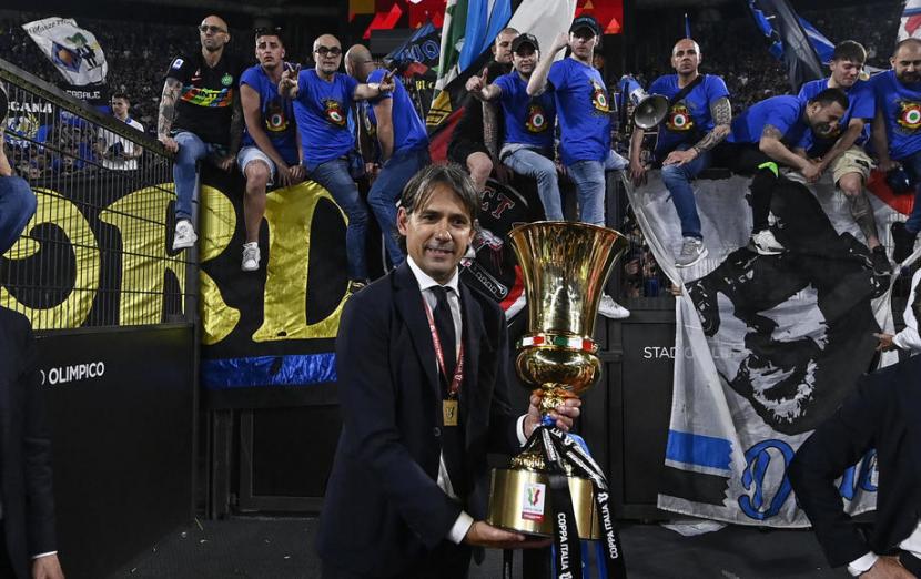 Pelatih Inter Milan Simone Inzaghi mengangkat Piala Coppa Italia di depan para interisti yang memadati Stadion Olympico, Roma seusai timnya mengalahkan Juventus, Kamis (12/5/2022). 