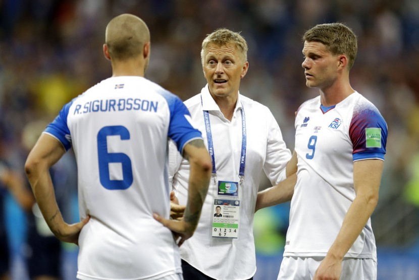 Pelatih Islandia, Heimir Hallgrimsson (tengah), menghibur para pemainnya seusai tersingkir dari Piala Dunia 2018.