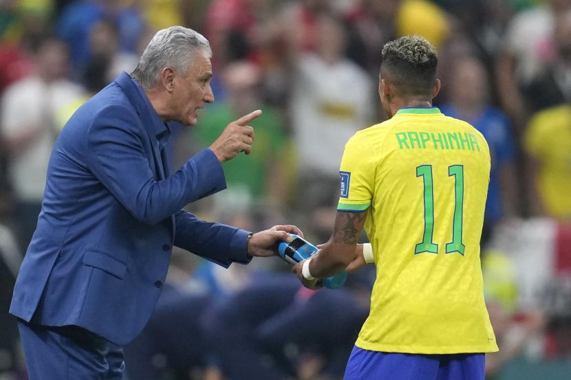 Pelatih kepala Brasil Tite, kiri, berbicara dengan Raphinha Brasil selama pertandingan sepak bola grup G Piala Dunia antara Brasil dan Serbia, di Stadion Lusail di Lusail, Qatar, Kamis, 24 November 2022. 