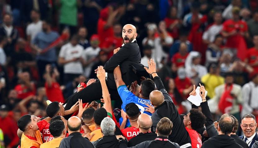  Pelatih kepala Maroko Walid Reragui (atas) dan para pemainnya merayakan setelah memenangkan pertandingan sepak bola perempat final Piala Dunia FIFA 2022 antara Maroko dan Portugal di Stadion Al Thumama di Doha, Qatar, Sabtu (10/12).