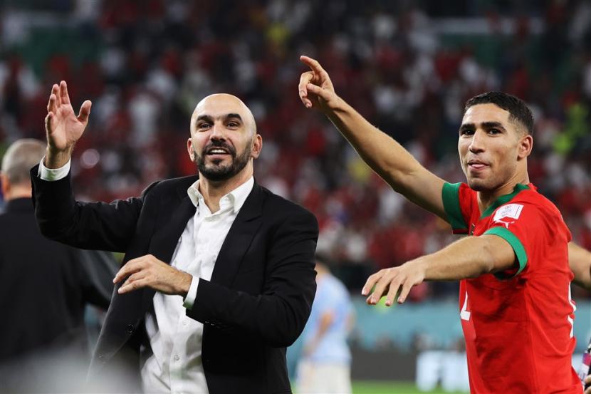  Pelatih kepala Maroko Walid Reragui merayakan dengan Achraf Hakimi setelah pertandingan sepak bola babak 16 besar Piala Dunia FIFA 2022 antara Maroko dan Spanyol di Education City Stadium di Doha, Qatar, Selasa, 6 Desember 2022.