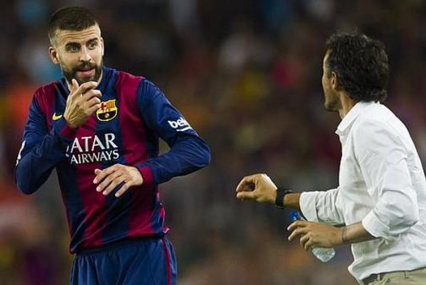 Pelatih Luis Enrique tengah berbicara kepada Gerard Pique 