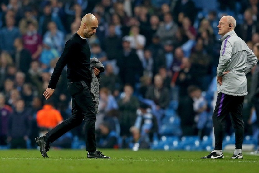 Pelatih Manchester City Pep Guardiola berjalan gontai setelah timnya tersingkir dari Liga Champions.