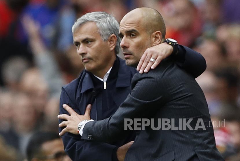 Pelatih Manchester City Pep Guardiola dan pelatih Manchester United Jose Mourinho berpelukan usai derby Manchester di Stadion Old Traford.