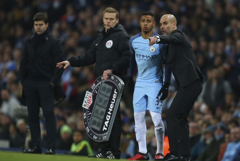 Pelatih Manchester City, Pep Guardiola (kanan) memberikan instruksi kepada Gabriel Jesus pada laga debutnya bersama City saat laga melawan Tottenham Hotspur, Sabtu (21/1).