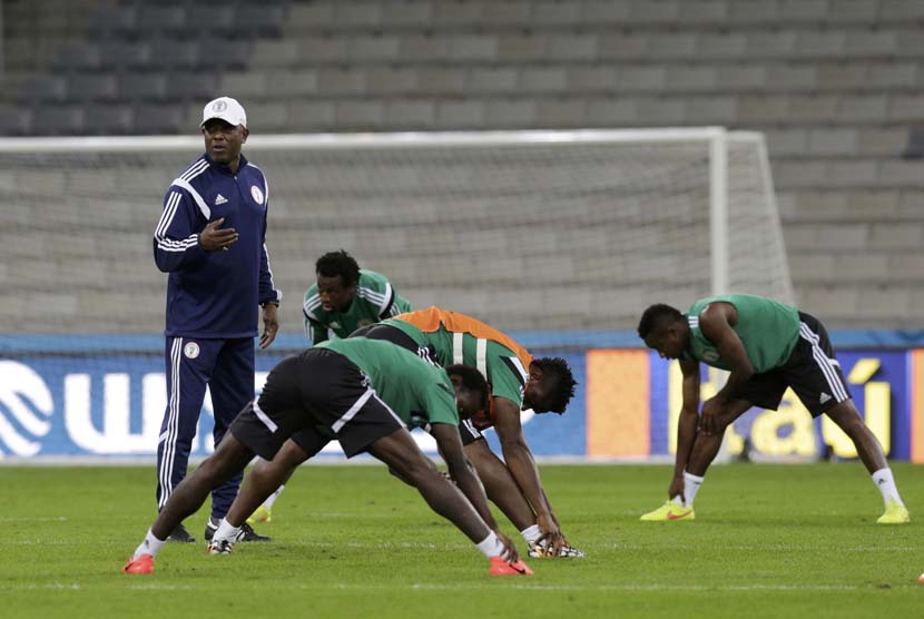Pelatih Nigeria nasional kepala tim sepak bola Stephen Keshi (kiri, memakai topi) memberikan instruksi kepada pemainnya selama sesi pelatihan di stadion sepak bola Arena Baixada di Curitiba, 15 Juni 2014.
