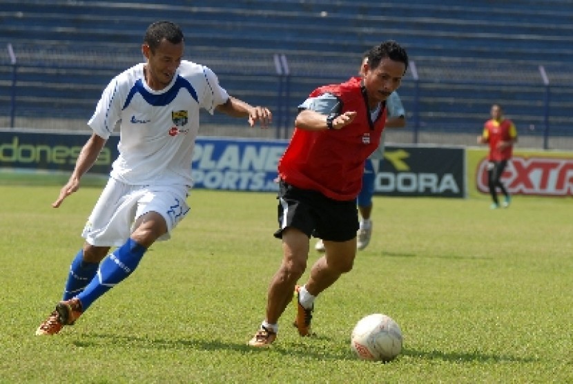 Pelatih Persib Jajang Nurjaman (kanan) berebut bola dengan anak asuhnya dalam sebuah latihan.