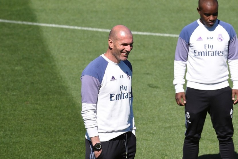 Pelatih Real Madrid Zinedine Zidane (kiri) tertawa saat menyaksikan para pemainnya berlatih.