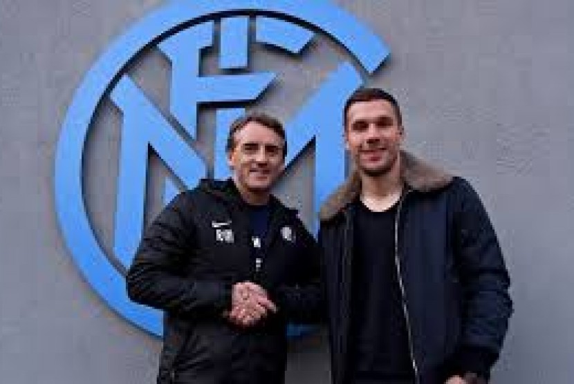 Pelatih Roberto Mancini bersalaman dengan Lukas Podolski