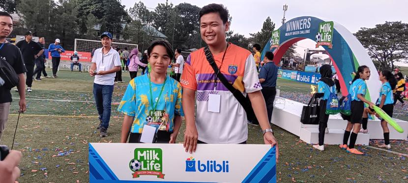 Pelatih SDN Mekarjaya 12 A, Erik Ilham Maulana dan Pemain SDN Mekarjaya 12 A, Andara Alisya yang juga terpilih sebagai Best Player KU 12 pada Ajang MilkLife Soccer Challenge Jakarta Series 1 2024.