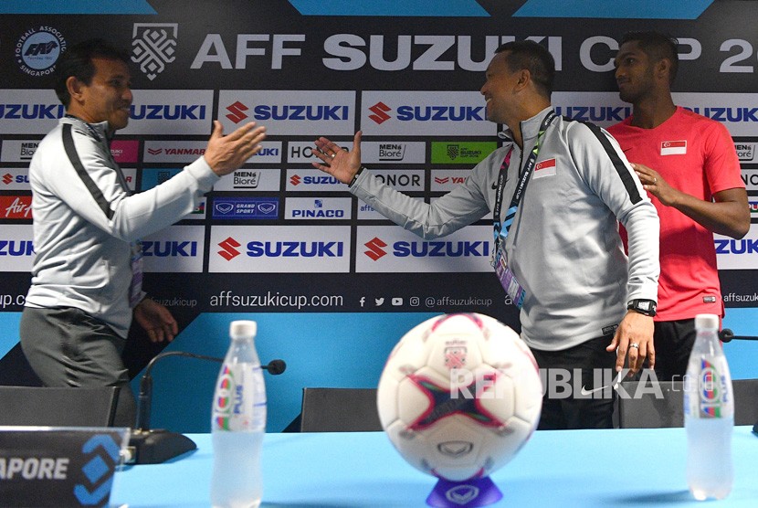 Pelatih timnas Indonesia Bima Sakti (kiri) berbincang dengan pelatih timnas Singapura Fandi Ahmad (tengah) serta pemain timnas Singapura Hariss Harun (kanna) saat konferensi pers piala AFF 2018 di Stadion Nasional, Singapura, Kamis (8/11/2018). 