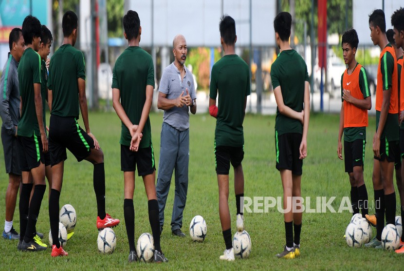 Pelatih Timnas U-18 Fakhri Husaini (tengah) memberikan arahan kepada pemainnya saat latihan di Lapangan Becamex Binh Duong, Vietnam, Kamis (15/8/2019).