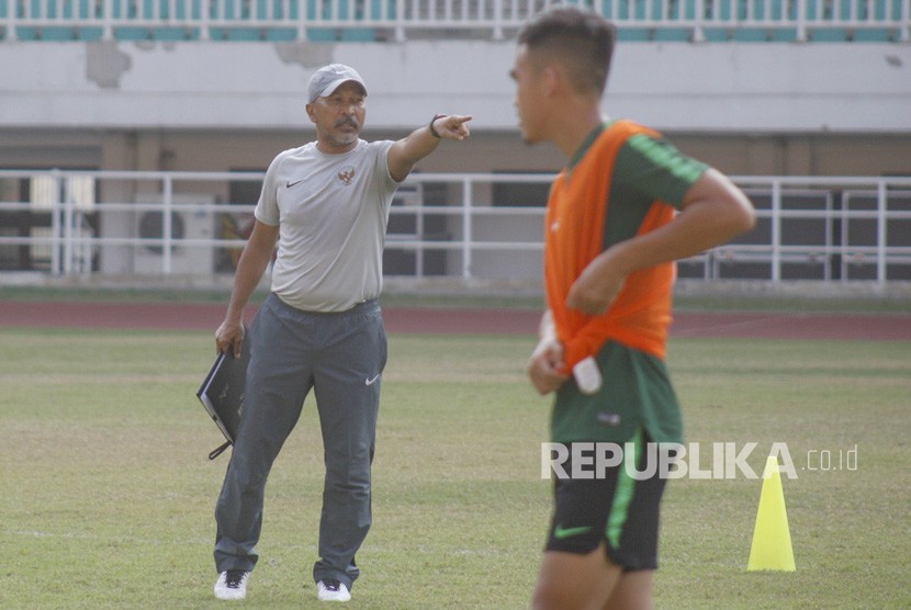Pelatih timnas U-19 Indonesia Fakhri Husaini (kiri) memberikan instruksi kepada para pemainnya saat latihan di Stadion Pakansari, Cibinong, Bogor, Jawa Barat, Senin (30/9/2019). 