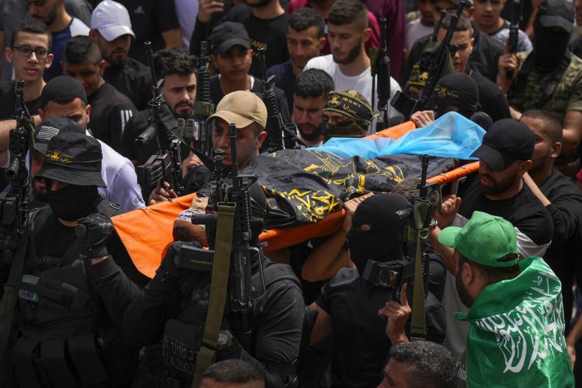 Pelayat Palestina, beberapa bersenjata, membawa jenazah Amjad al-Fayyed, 17, selama pemakamannya di kamp pengungsi Tepi Barat Jenin, Sabtu, 21 Mei 2022. Pasukan Israel menembak dan membunuh al-Fayyed saat pertempuran meletus ketika tentara masuk sebuah kota yang bergejolak di Tepi Barat yang diduduki Sabtu pagi, kata kementerian kesehatan Palestina dan media lokal.