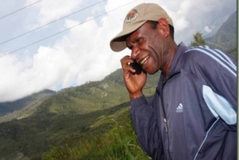 Seorang penduduk lembah Baliem, Papua menelepon menggunakan Telkomsel