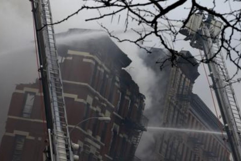 Pemadam kebakaran berjuang memadamkan api yang menyelimuti banguan di East Village, NY, Jumat (26/3).