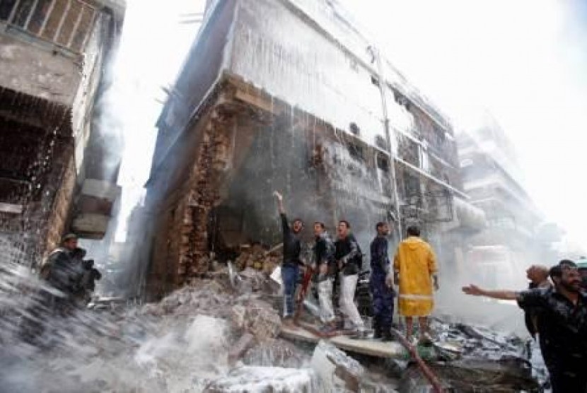 Pemadam kebakaran berusaha memadamkan api akibat jatuhnya pesawat militer di gedung dekat Charage Square, Sanaa, Yaman, 