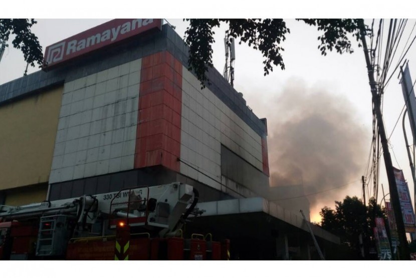 Pemadam kebakaran berusaha memadamkan api yang menyala di bagian belakang Gedung Ramayana Pasar Minggu, Kamis (18/5) pagi.